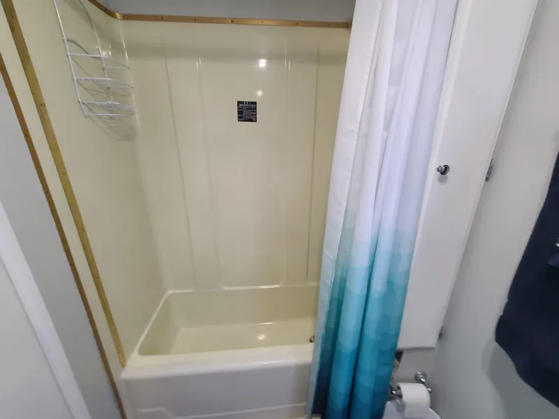 Slide: The Image of 1977 Stardust Cruisers houseboat bathroom with nautical decor, white vanity, and blue accents. - 17