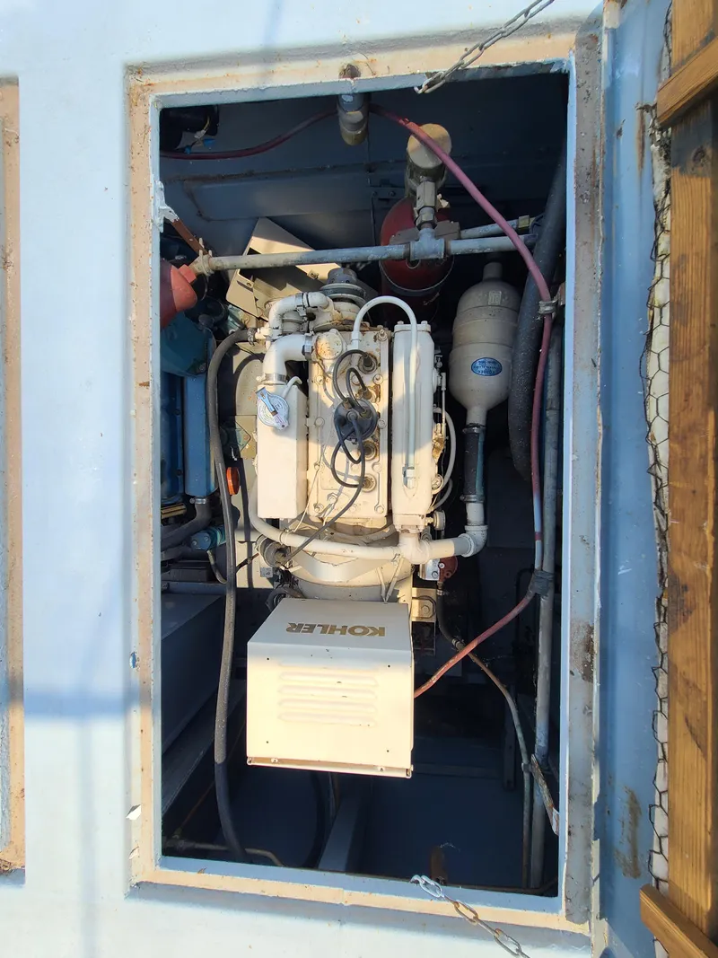 Slide: The Image of Engine compartment of a 1977 Stardust Cruisers houseboat, featuring a Kohler generator. - 23