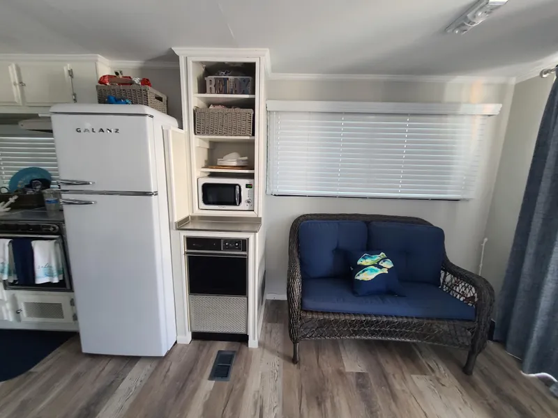 Slide: The Image of 1977 Stardust Cruisers houseboat docked, featuring a covered deck with table and American flag. - 4