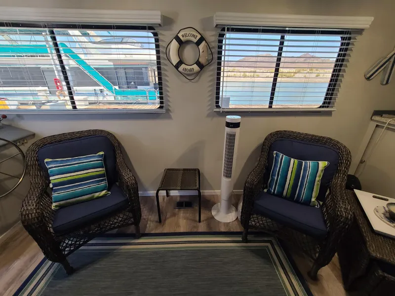 Slide: The Image of 1977 Stardust Cruisers houseboat interior with wicker furniture, striped cushions, and modern kitchen appliances. - 5