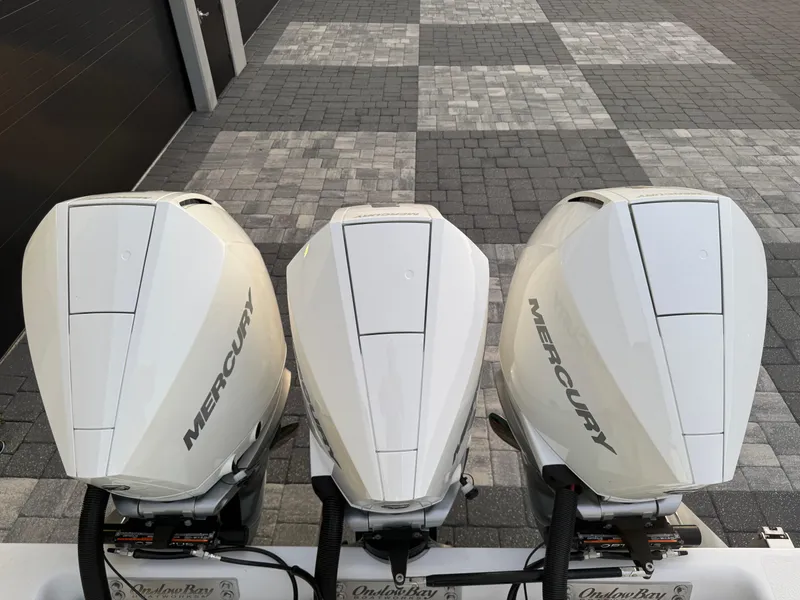 Slide: The Image of 2020 Onslow Bay 33 Tournament boat on trailer, teal hull, parked outdoors. - 56