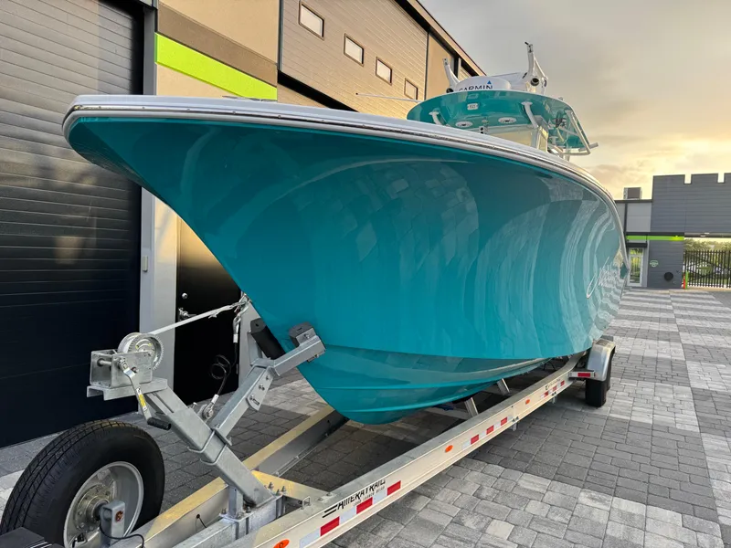 Slide: The Image of 2020 Onslow Bay 33 Tournament boat on trailer, parked in industrial area at sunset. - 57