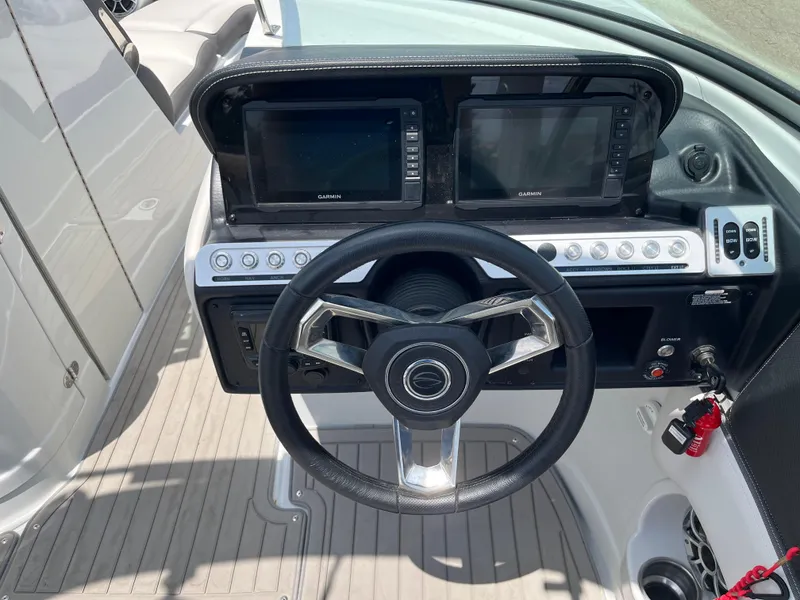 Slide: The Image of 2022 Crownline 280 SS boat dashboard with steering wheel and dual Garmin displays. - 10