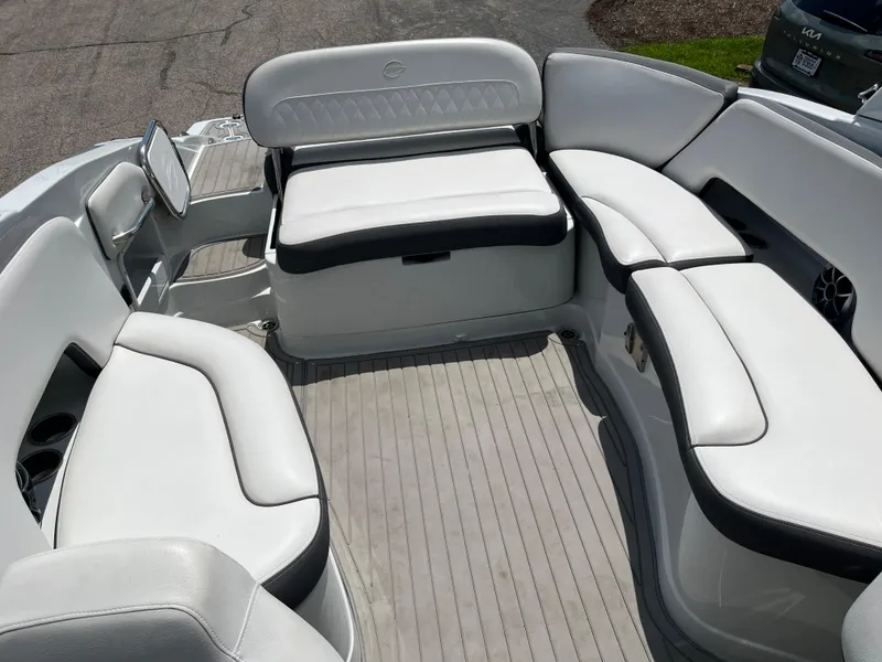 Slide: The Image of 2022 Crownline 280 SS boat interior with white cushioned seating and gray flooring. - 14