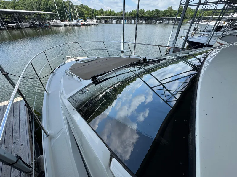 Slide: The Image of 2017 Sea Ray Sundancer 400 docked at marina, reflecting blue sky and clouds. - 18