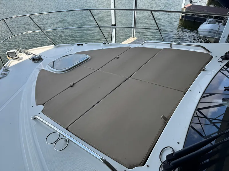 Slide: The Image of 2017 Sea Ray Sundancer 400 boat with sunpad on deck, docked by the water. - 21