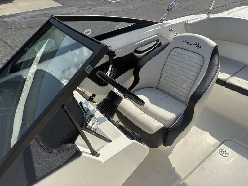 Slide: The Image of 2021 Sea Ray SPX 190 boat interior with steering wheel and comfortable seating. - 15
