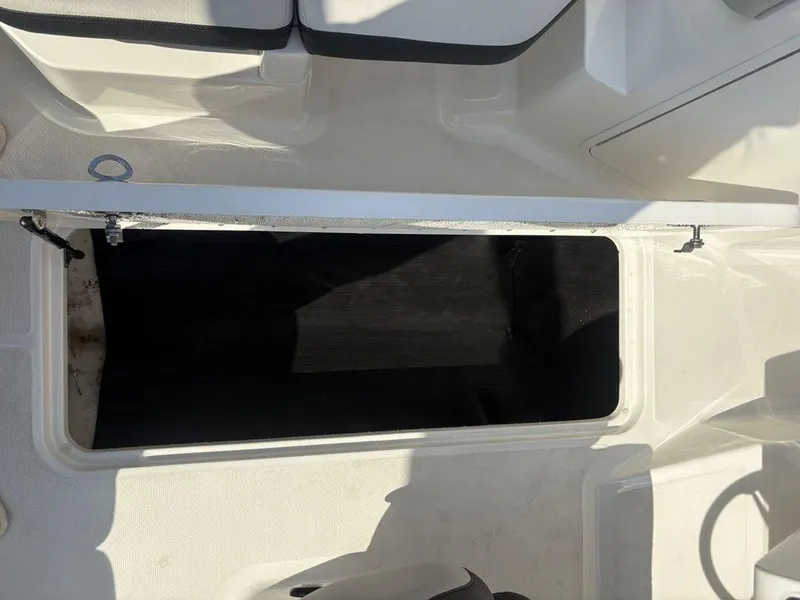 Slide: The Image of Open storage compartment on a 2021 Sea Ray SPX 190 boat, featuring white interior. - 21