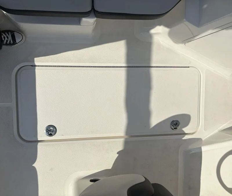 Slide: The Image of 2021 Sea Ray SPX 190 boat deck with storage compartment and seating area. - 23