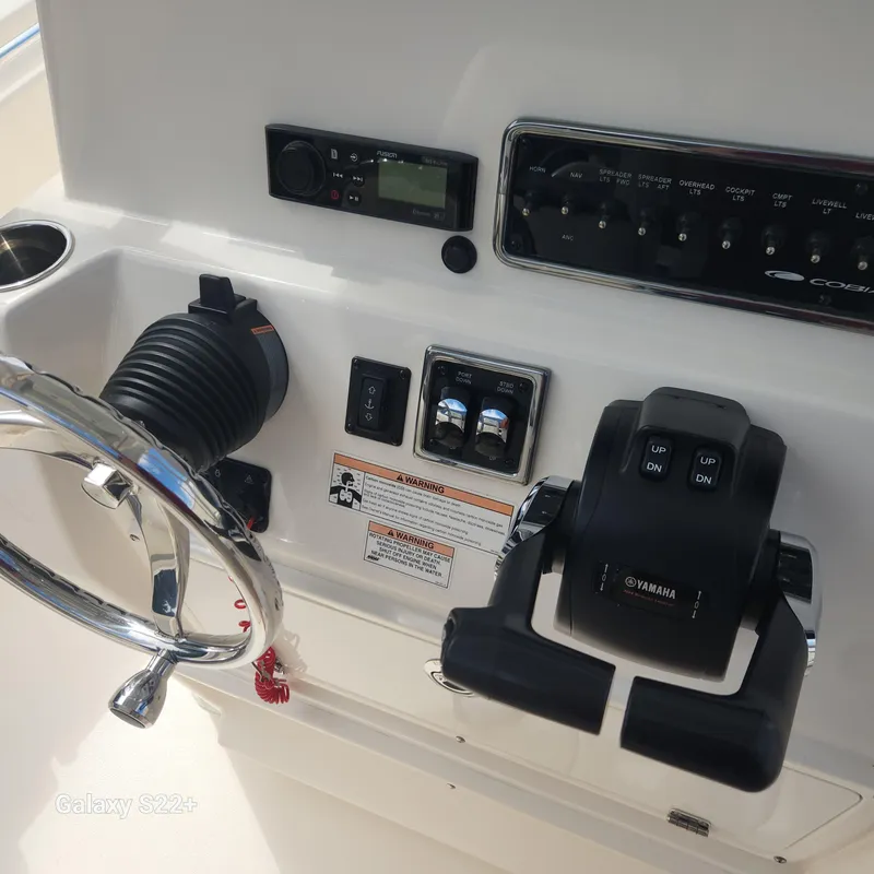 Slide: The Image of 2018 Cobia 261 Center Console dashboard with steering wheel and controls. - 18