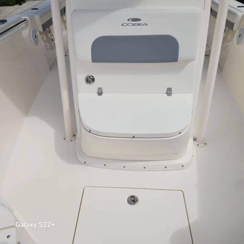 Slide: The Image of 2018 Cobia 261 Center Console boat interior, featuring seating and storage compartments. - 21