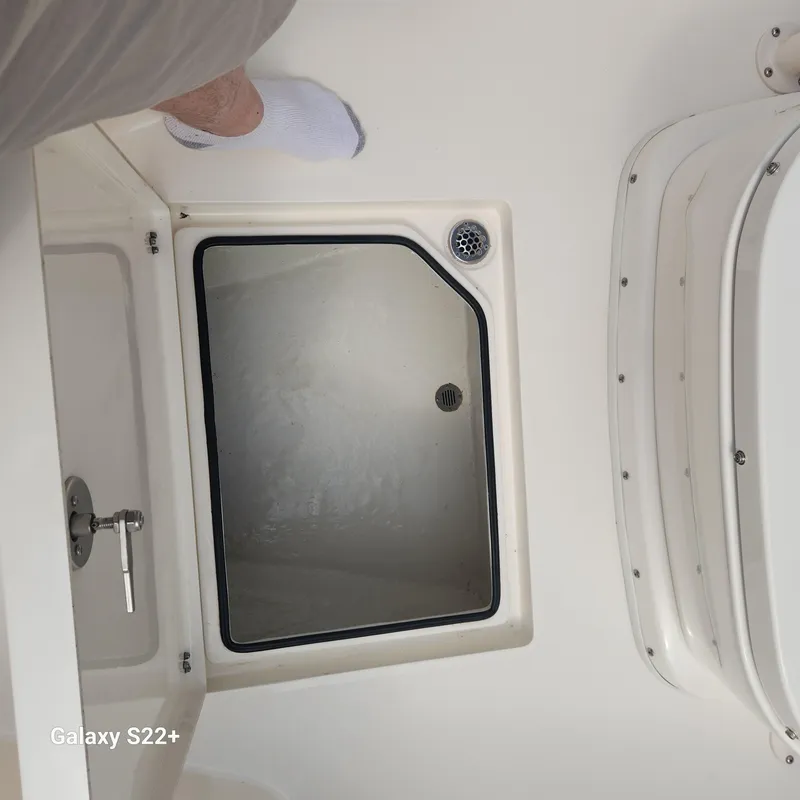 Slide: The Image of 2018 Cobia 261 Center Console boat deck with storage compartment and drain. - 22