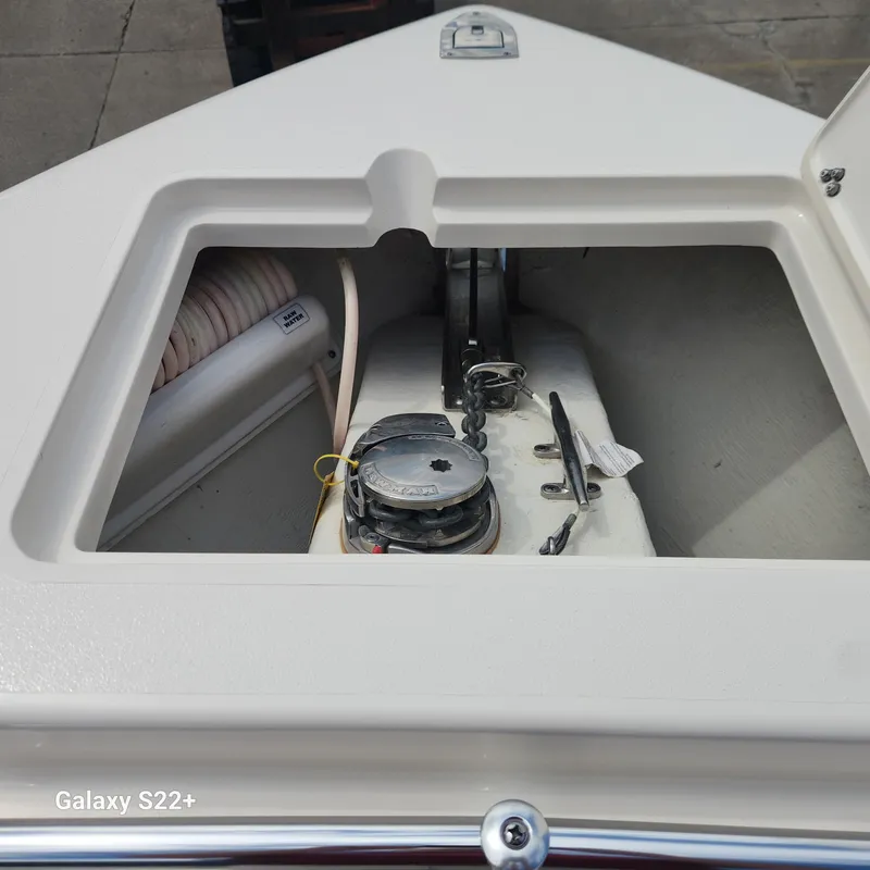 Slide: The Image of 2018 Cobia 261 Center Console anchor compartment with winch and rope storage. - 24