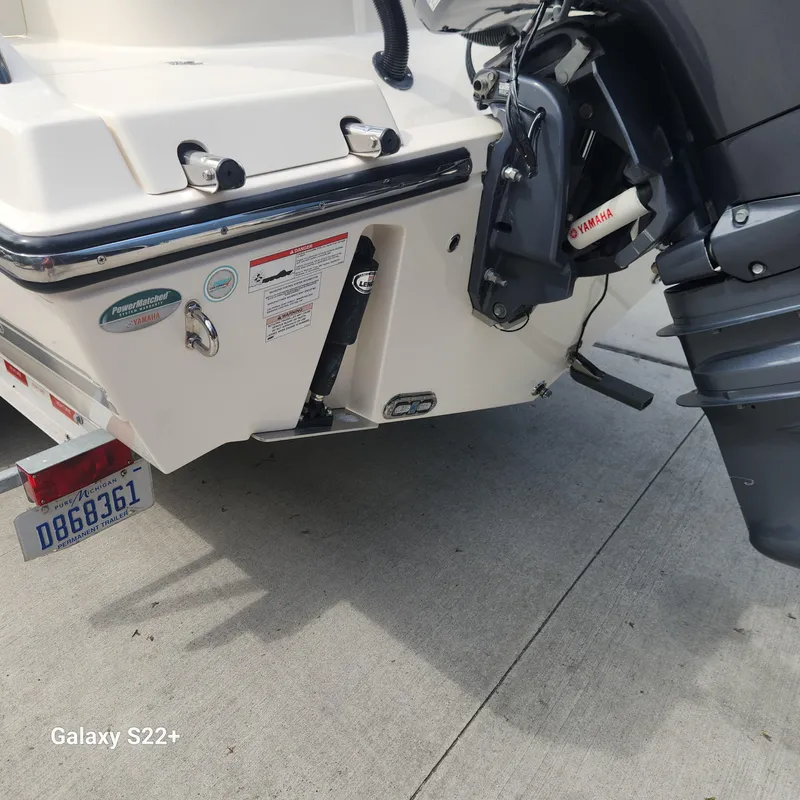 Slide: The Image of 2018 Cobia 261 Center Console boat with Yamaha outboard motor, parked on concrete. - 30
