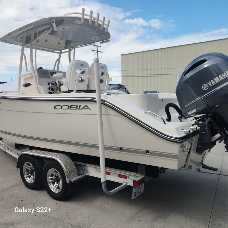 Slide: The Image of 2018 Cobia 261 Center Console boat on trailer with Yamaha engine, parked outdoors. - 4