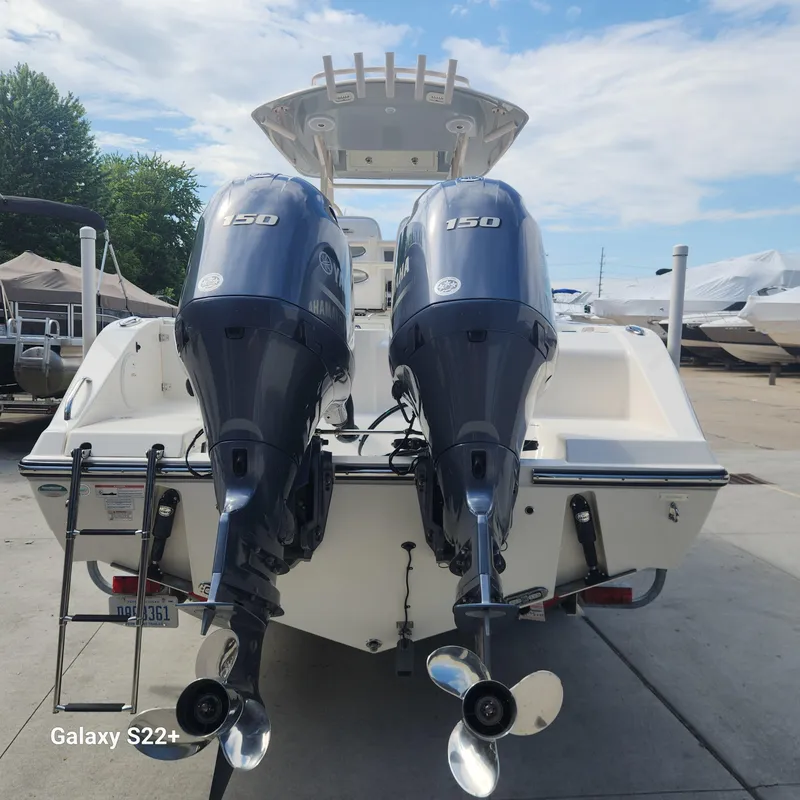 Slide: The Image of 2018 Cobia 261 Center Console with twin Yamaha 150 engines, docked outdoors. - 5