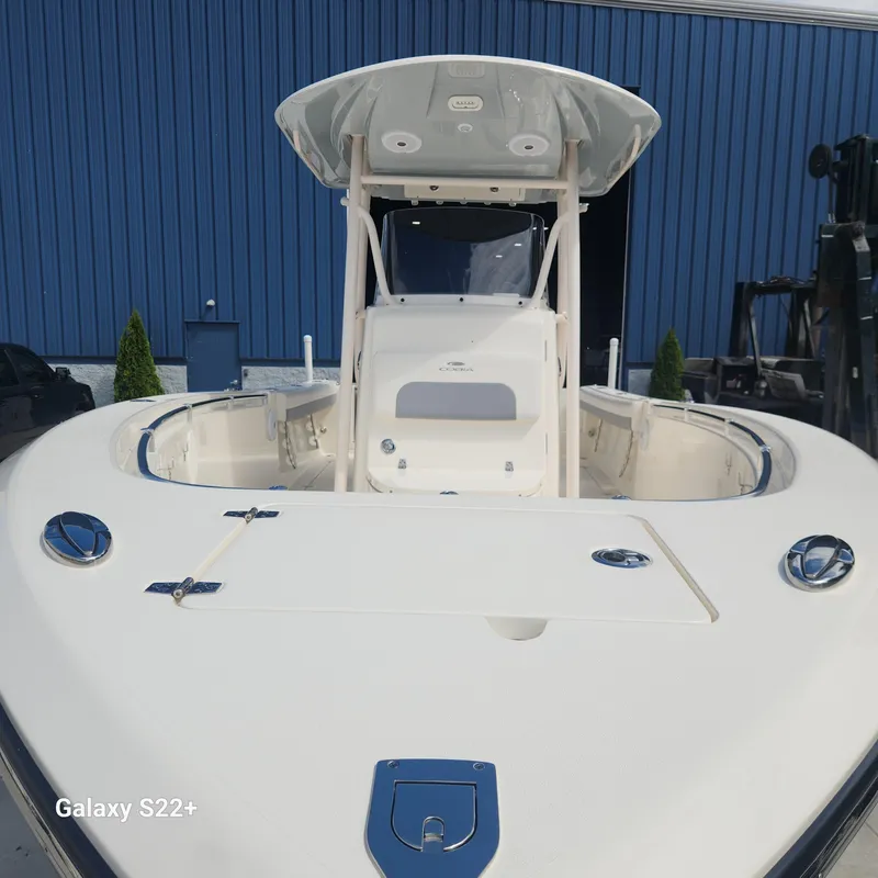 Slide: The Image of 2018 Cobia 261 Center Console boat with T-top, displayed outdoors. - 6