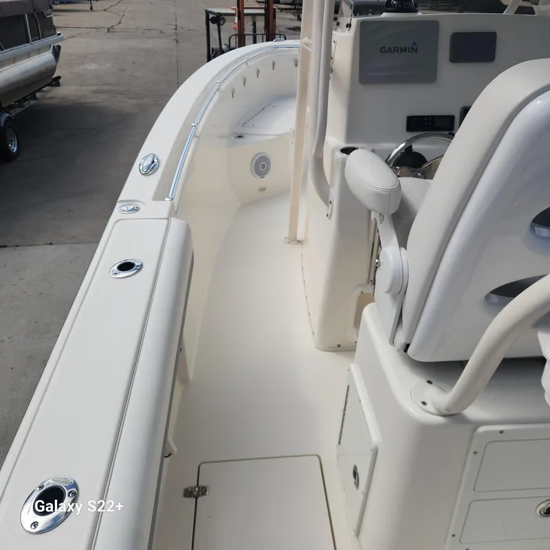 Slide: The Image of 2018 Cobia 261 Center Console boat interior with Garmin equipment, docked at a marina. - 8