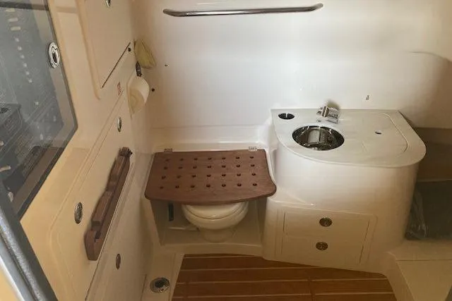 Slide: The Image of 2026 Grady-White Canyon 336 boat interior with compact bathroom and wooden accents. - 15