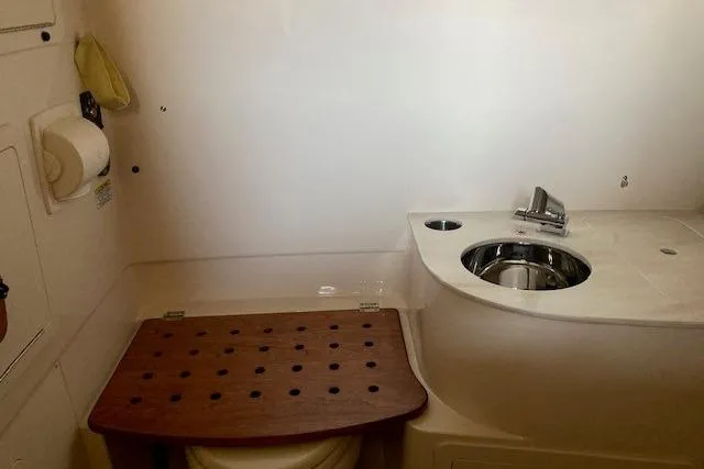 Slide: The Image of 2026 Grady-White Canyon 336 boat bathroom with sink and wooden seat cover. - 18