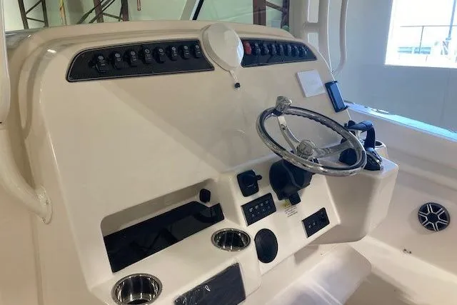 Slide: The Image of 2026 Grady-White Canyon 336 boat dashboard with steering wheel and controls. - 23