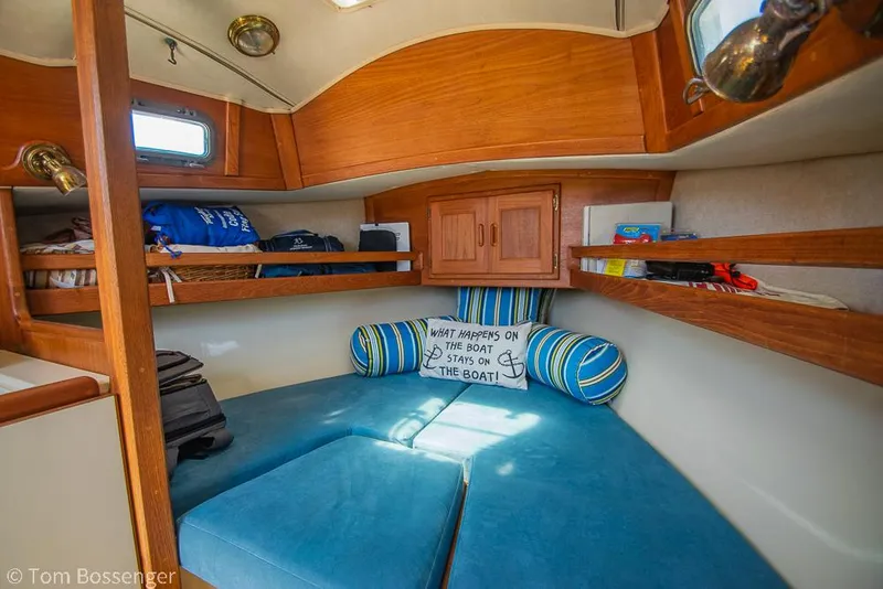 Slide: The Image of Cozy interior of 1993 Pacific Seacraft Flicka 20 sailboat with blue cushions and wooden shelves. - 12