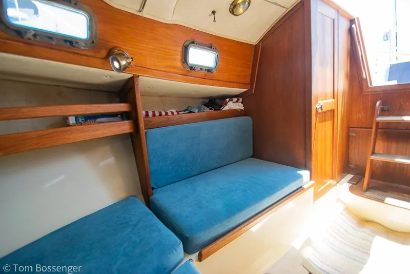 Slide: The Image of Interior of 1993 Pacific Seacraft Flicka 20 sailboat with blue cushions and wooden accents. - 13
