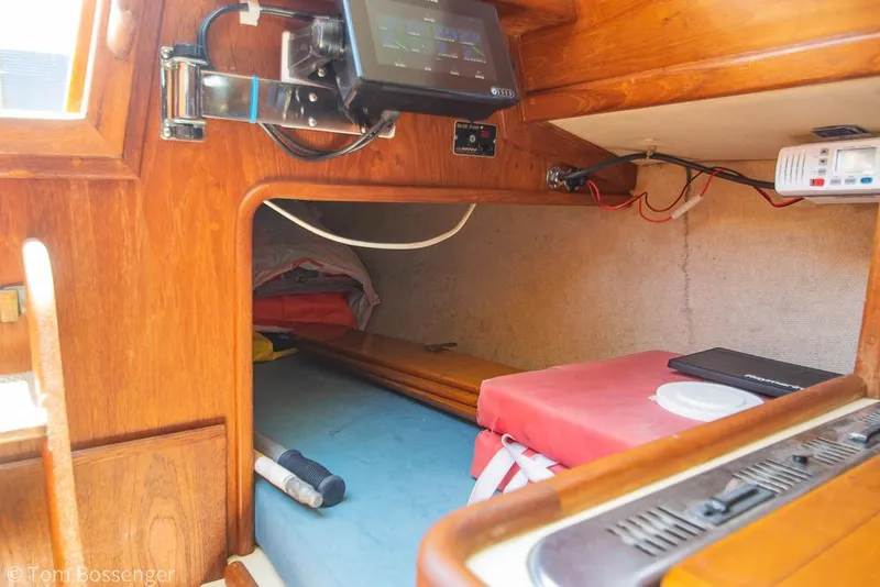 Slide: The Image of Interior cabin of a 1993 Pacific Seacraft Flicka 20 sailboat, featuring wooden finish and navigation equipment. - 15