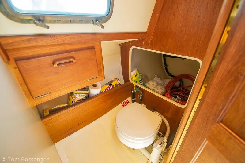 Slide: The Image of 1993 Pacific Seacraft Flicka 20 boat interior with wooden cabinetry and compact toilet. - 16