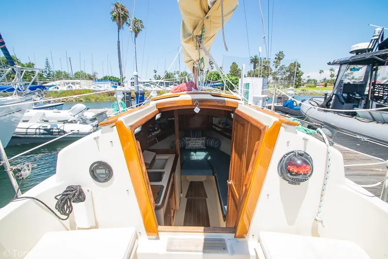 Slide: The Image of 1993 Pacific Seacraft Flicka 20 sailboat interior view at marina, with open cabin doors. - 23