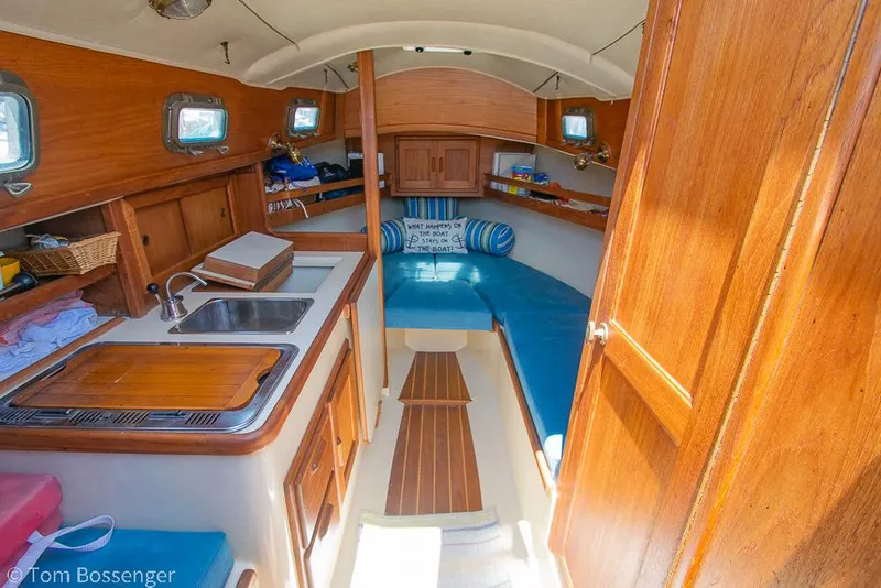 Slide: The Image of Interior of 1993 Pacific Seacraft Flicka 20 sailboat with wooden cabinetry and blue seating. - 6