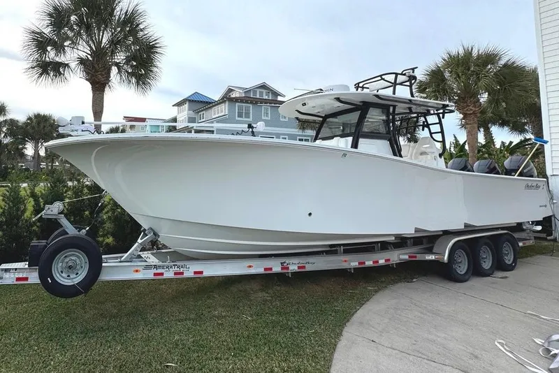 The Image of 2024 Onslow Bay 37 Tournament boat on trailer, parked near palm trees and houses. - 0