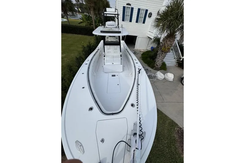 Slide: The Image of 2024 Onslow Bay 37 Tournament boat docked near a house with palm trees. - 15