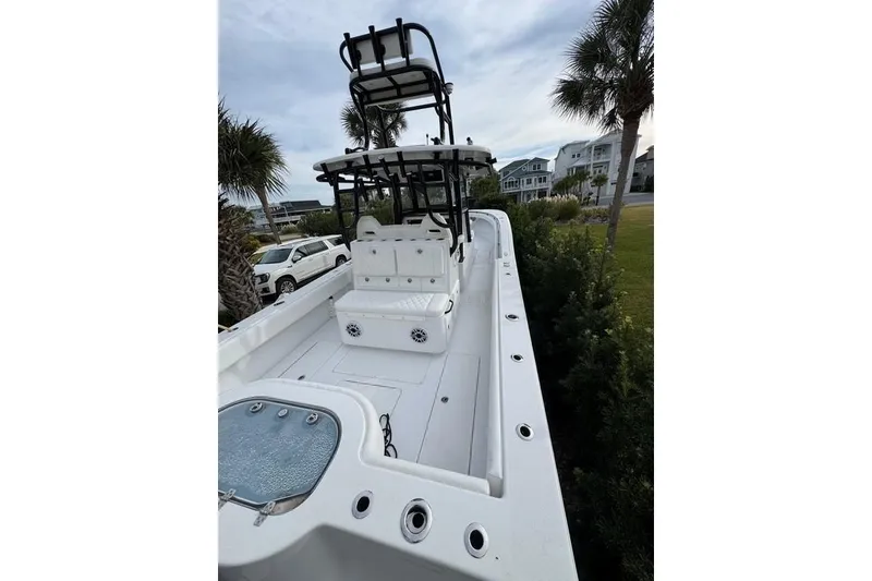 Slide: The Image of 2024 Onslow Bay 37 Tournament boat with spacious deck and seating, parked near palm trees. - 18