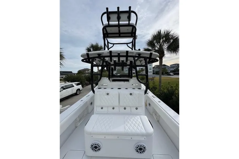 Slide: The Image of 2024 Onslow Bay 37 Tournament boat with white seating and black tower, parked near palm trees. - 20