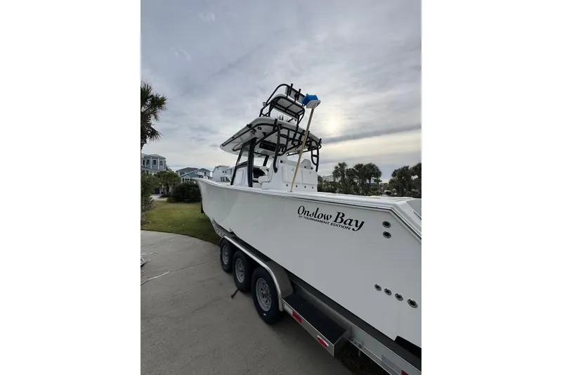 Slide: The Image of 2024 Onslow Bay 37 Tournament boat on trailer, parked outdoors under cloudy sky. - 25