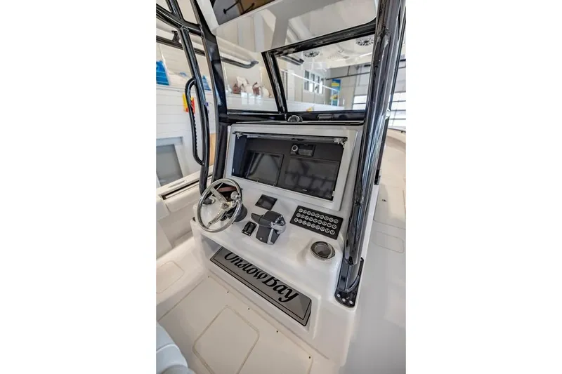 Slide: The Image of 2024 Onslow Bay 37 Tournament boat console with steering wheel and controls. - 33
