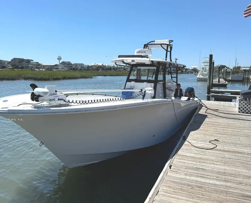 Slide: The Image of 2024 Onslow Bay 37 boat on trailer, covered, with Mercury engines, parked outdoors. - 7