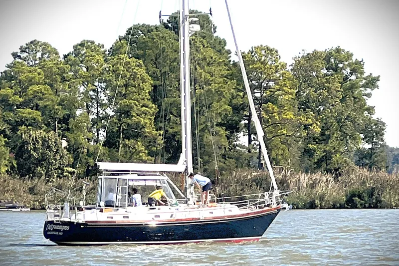 Slide: The Image of Sailboat Bristol 41.1 (1983) cruising on a river with lush green trees in the background. - 17