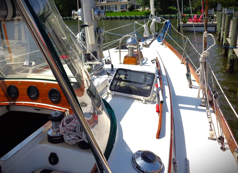 Slide: The Image of 1983 Bristol 41.1 sailboat deck with ropes and winch, docked by a waterfront. - 13
