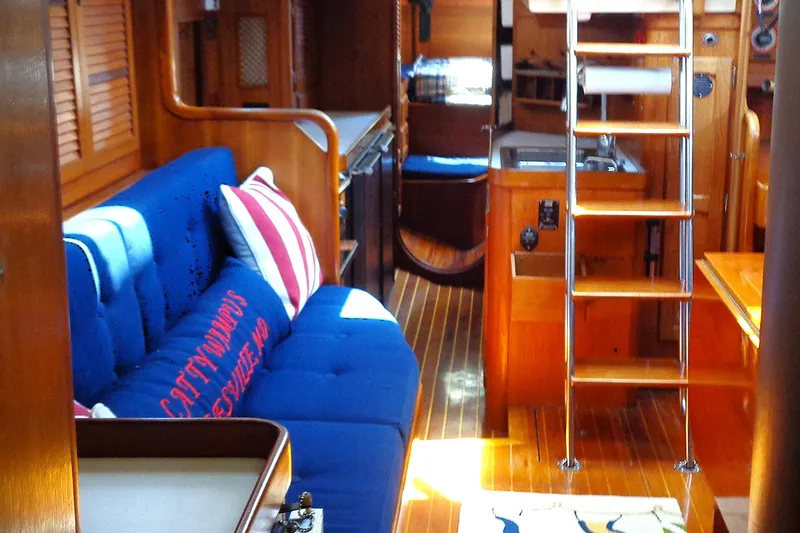 Slide: The Image of Interior of 1983 Bristol 41.1 yacht with blue seating, wooden finishes, and ladder. - 1