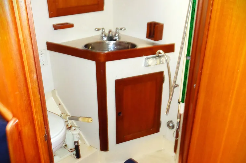Slide: The Image of Compact bathroom in a 1983 Bristol 41.1 boat with wooden cabinetry and stainless steel sink. - 9