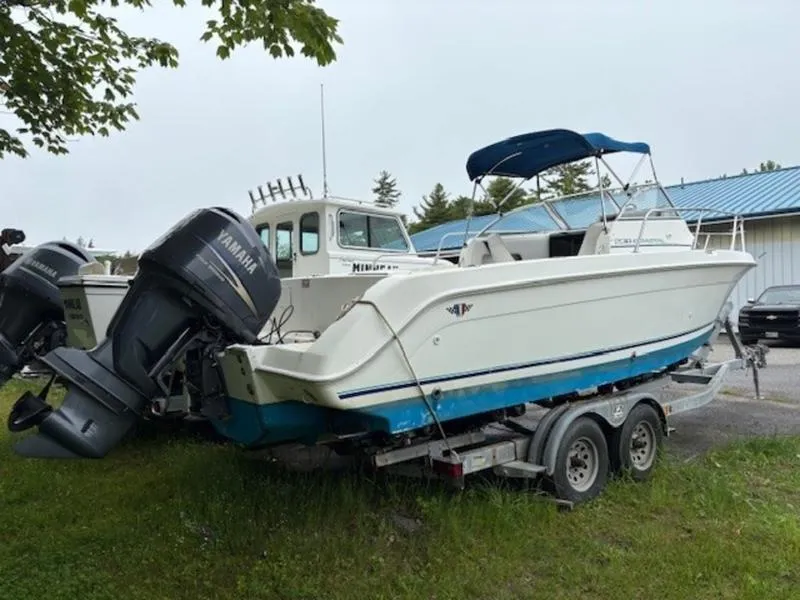 Slide: The Image of 1995 Wellcraft 238 Coastal boat on trailer with Yamaha outboard motor, parked outdoors. - 5