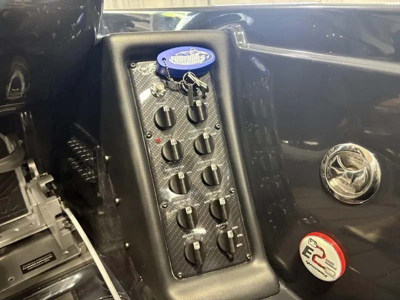 Slide: The Image of Control panel of a 2025 Phoenix 721 ZXL boat with switches and keychain. - 21