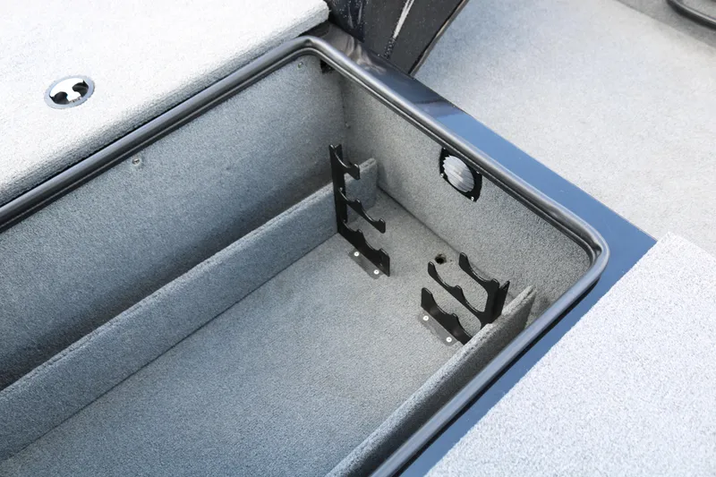 Slide: The Image of 2020 Alumacraft Pro 185 boat storage compartment with rod holders and carpeted interior. - 19