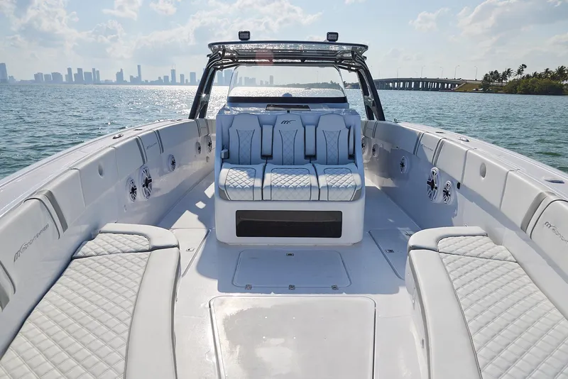 Slide: The Image of 2021 Midnight Express 43' Open boat interior with luxurious seating, ocean view, and city skyline. - 8
