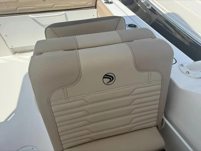 Slide: The Image of 2025 Edgewater 248CX boat seat with beige upholstery and logo detail. - 11