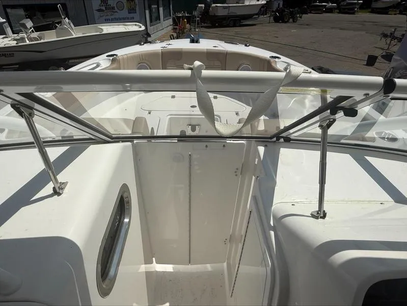 Slide: The Image of 2025 Edgewater 248CX boat interior with seating and railing, docked outdoors. - 3