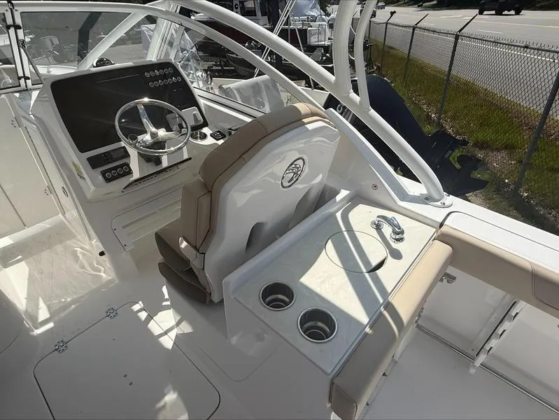 Slide: The Image of 2025 Edgewater 248CX boat interior with steering wheel, control panel, and seating area. - 4