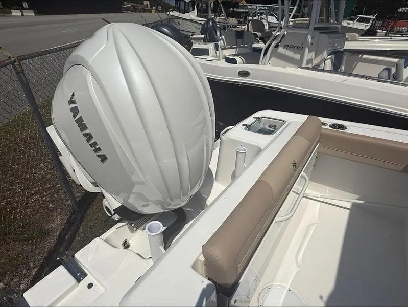 Slide: The Image of 2025 Edgewater 248CX boat with Yamaha outboard motor, featuring beige seating and rod holders. - 8
